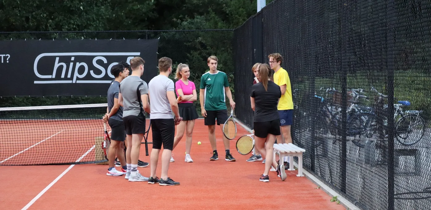 Studenten op de tennisbaan tijdens een activiteit van T.C. Ludica