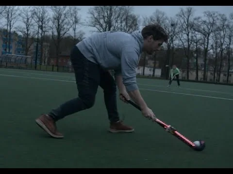 Student test de Stick Together-hockeystick met verlichte leds op het hockeyveld